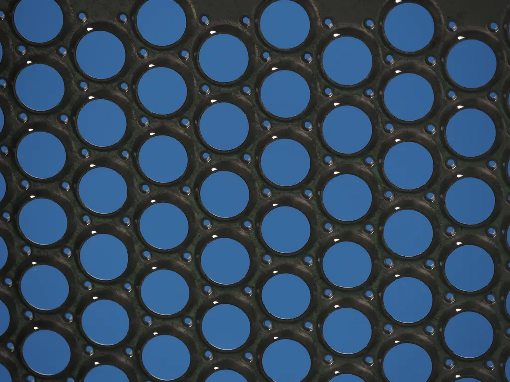 circular metal holes in a steel panel on a train