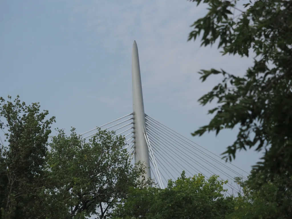 the spire of a suspension bridge visible above three