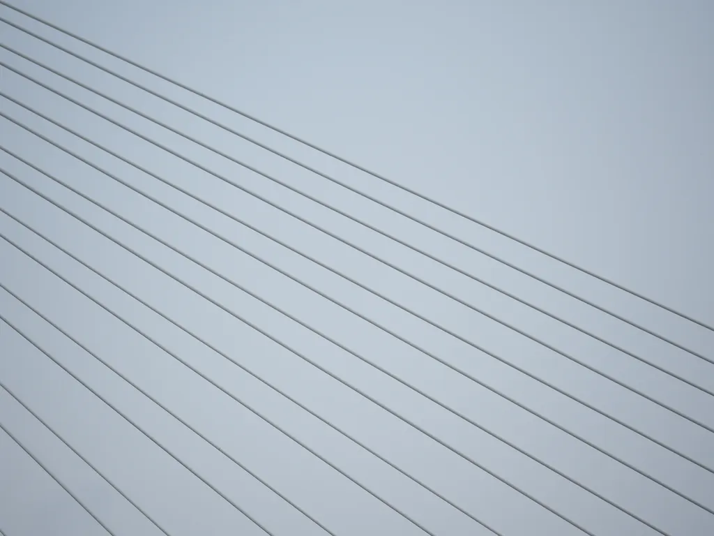 the cables of a suspension bridge against a grey sky