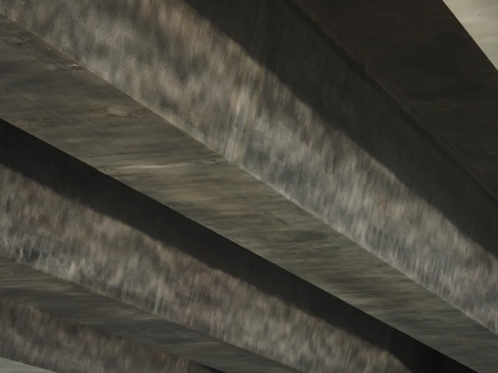 light reflecting off of a river and onto the underside of a bridge