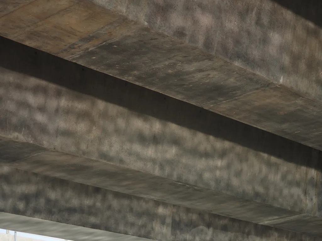 light reflecting off of a river and onto the underside of a bridge