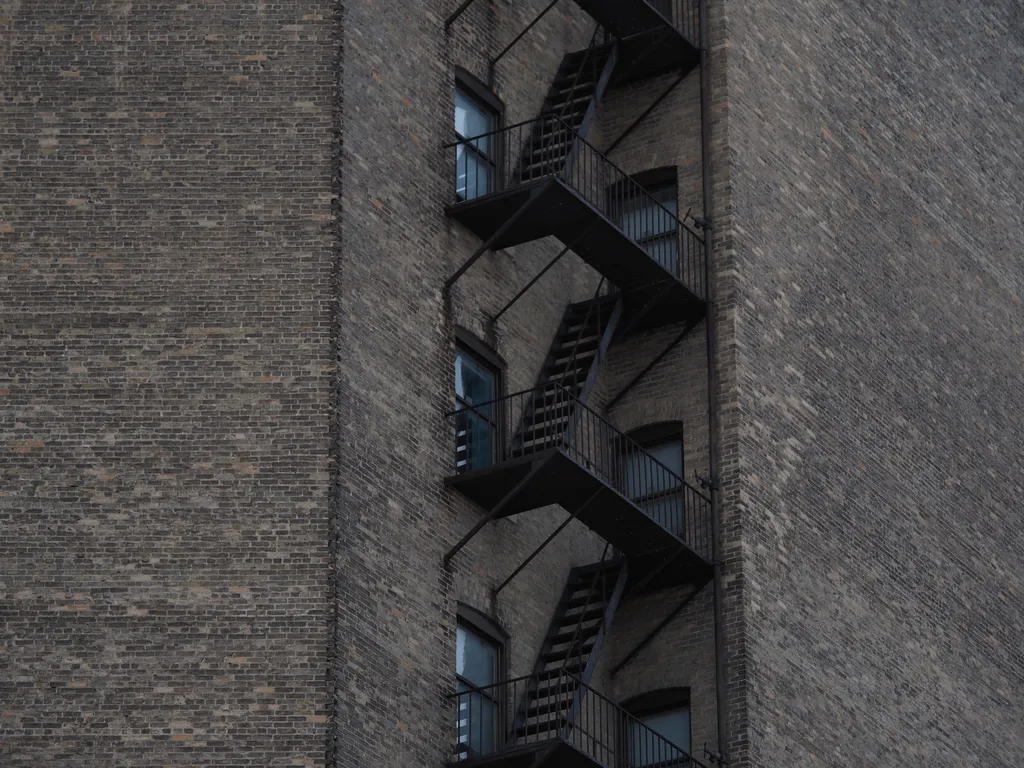 a metal fire eescape down the corner of a large brick building