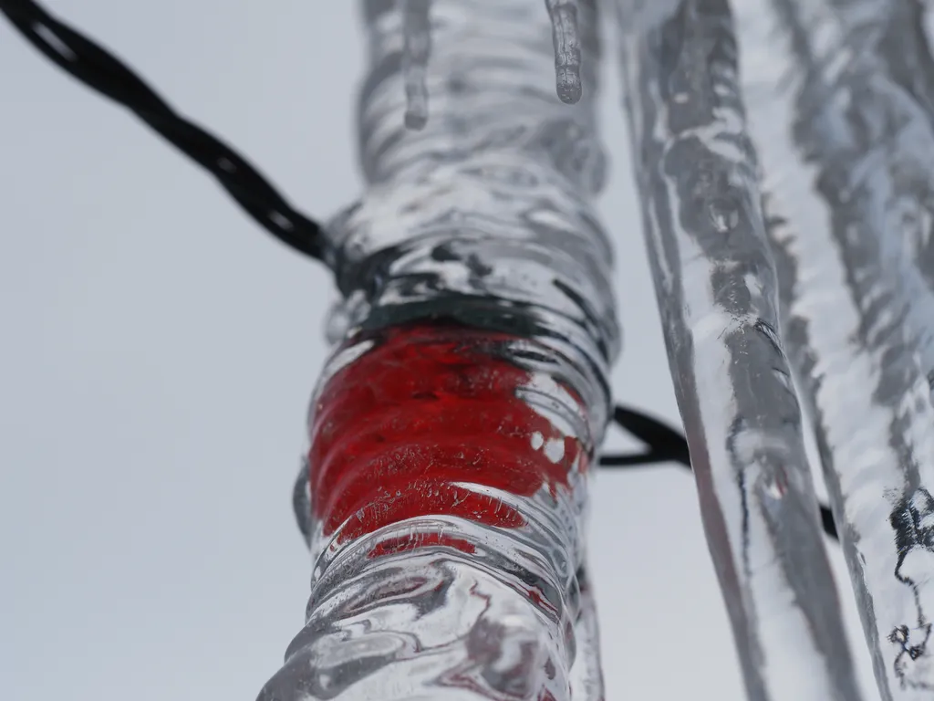 a christmas light trapped in an icicle