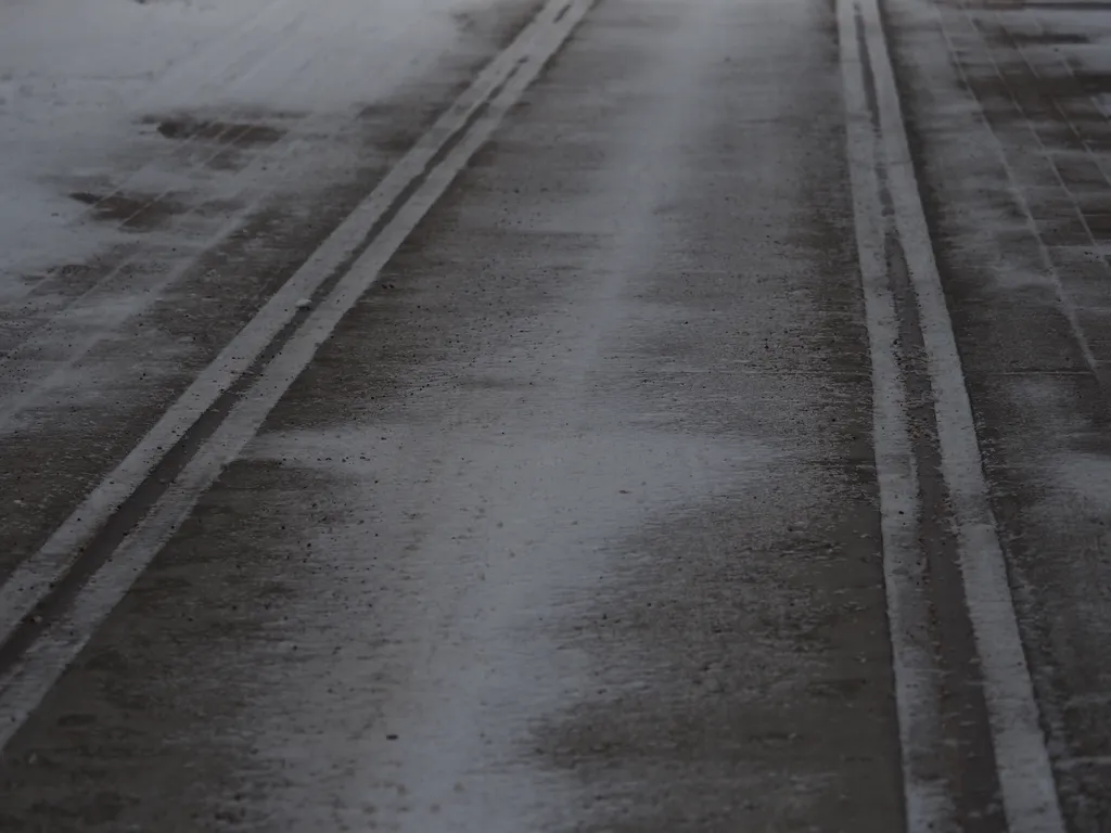 snow on unused streetcar rails in a back lane