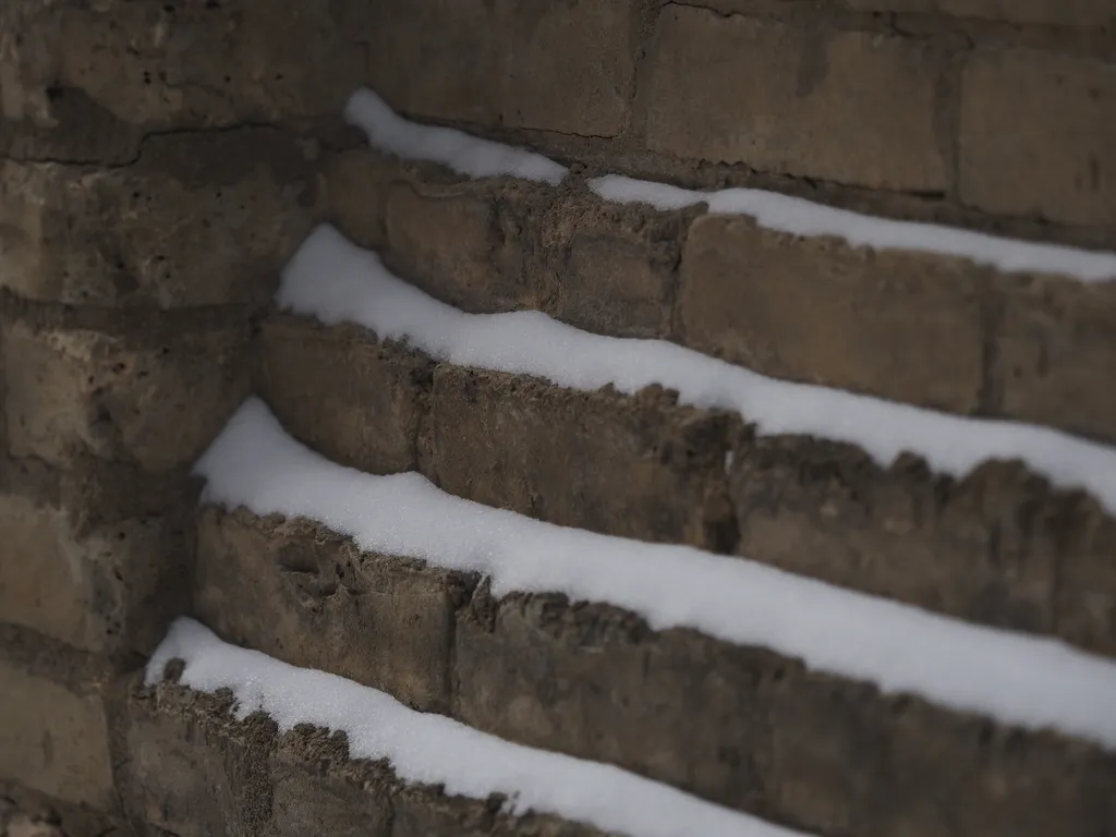 snow gathered on layered bricks