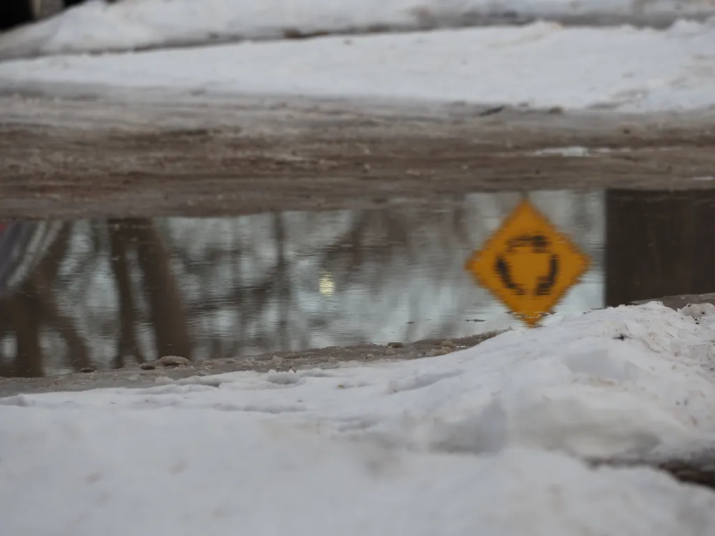 a street sign reflected in a puddle