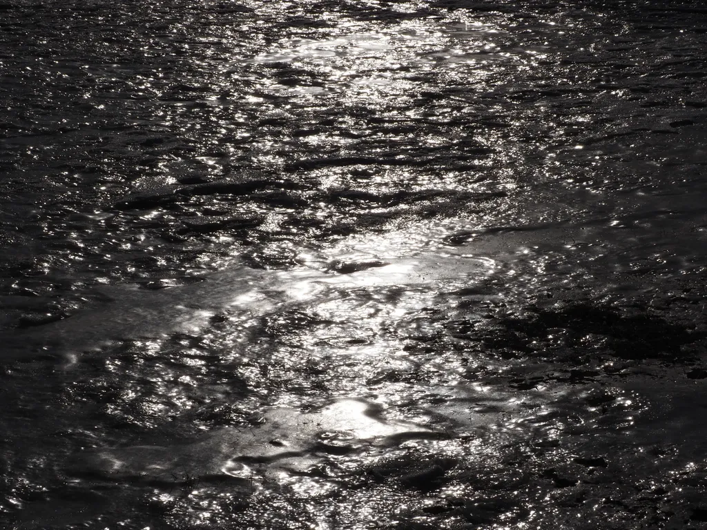 the setting sun reflecting on an uneven field of ice