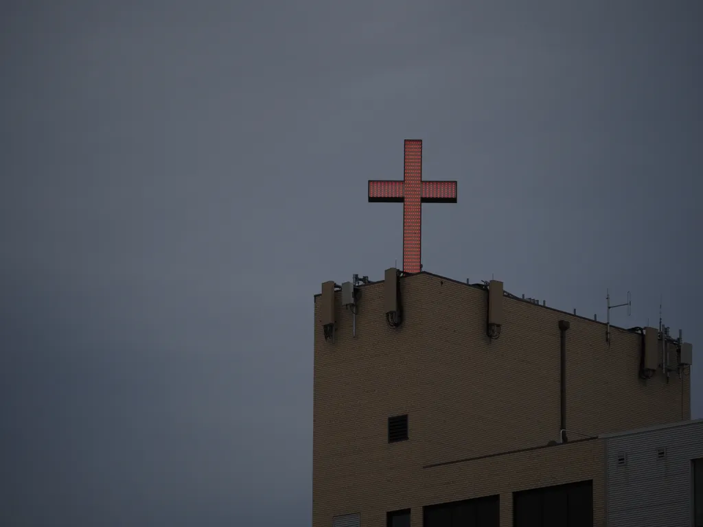 a large red cross light on a hospital