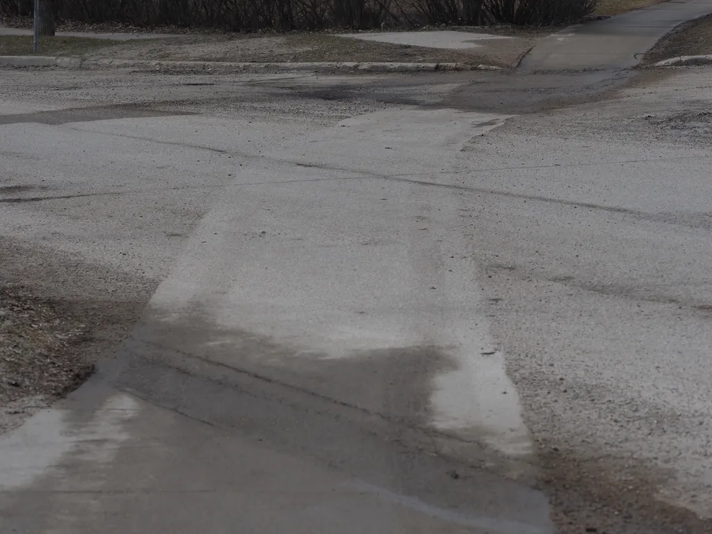 a path in a street where a sidewalk cleaner drove through