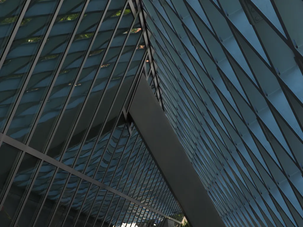 a glass wall meeting a diamond mesh grid