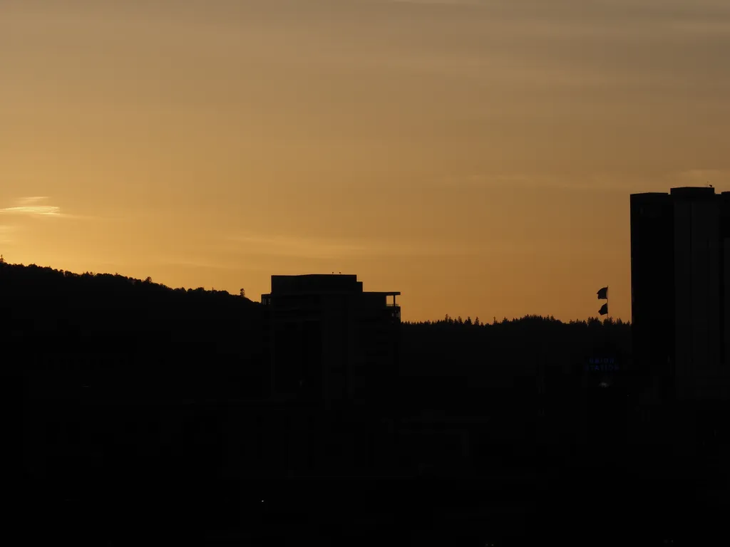 the sun setting behind a hill