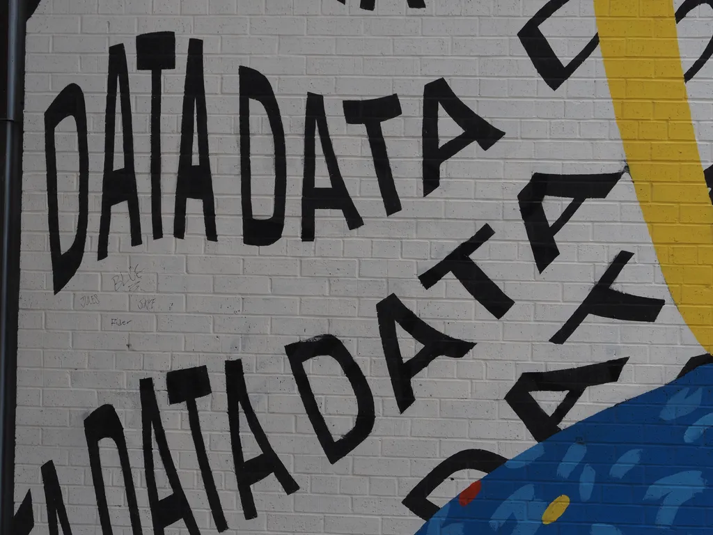 the word data written repeatedly as part of a mural on a brick wall