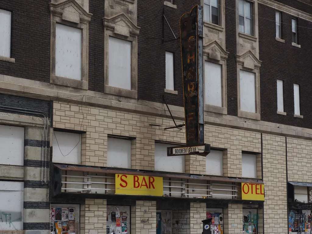 the boarded up exterior of a former hotel