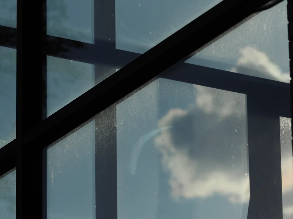 clouds visible through the windowed atrium of an apartment building