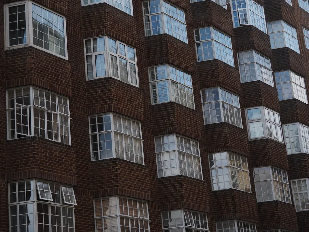 a brick apartment building with bay windows