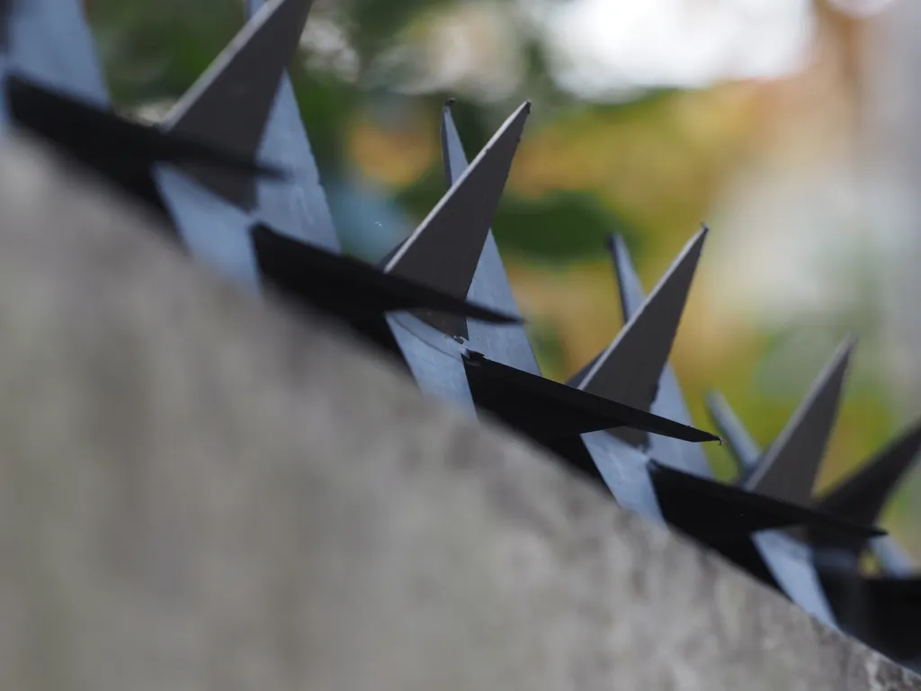 black metal spikes along the top of a stone wall