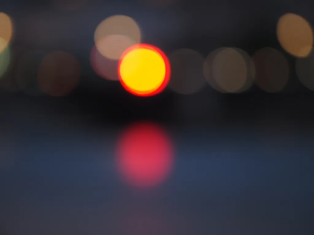 a purposefully blurry shot of cars crossing a bridge over a river at night