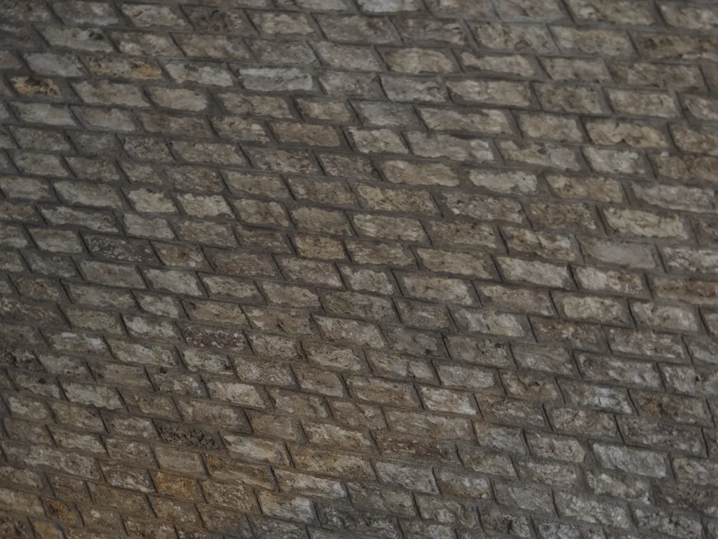 stones forming an arch in  a tunnel under a bridge