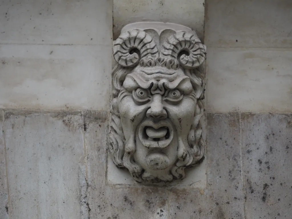 an angry satyr grotesque on a bridge