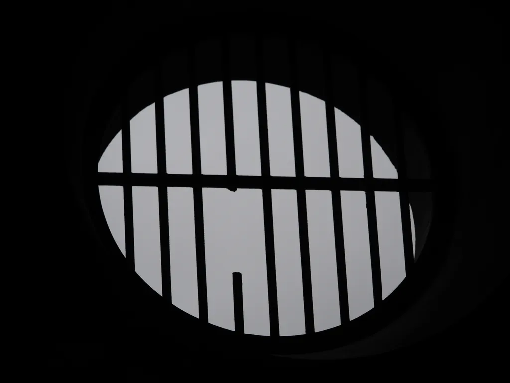 a broken metal grille in a hole