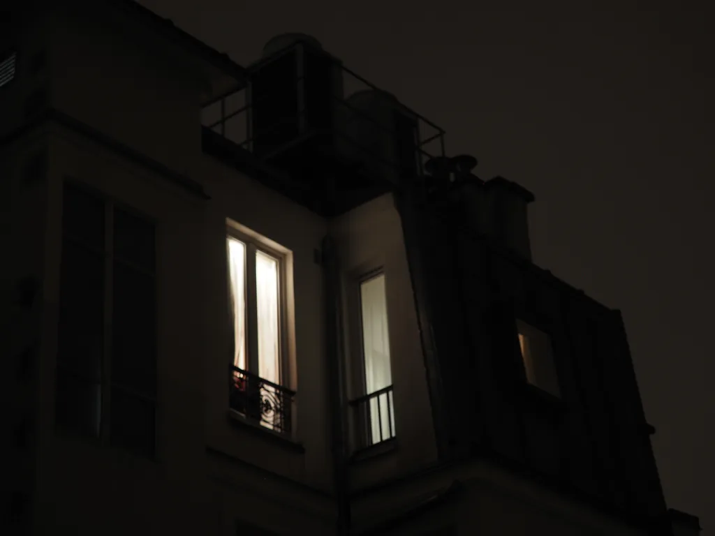 a lit window in a hotel room at night