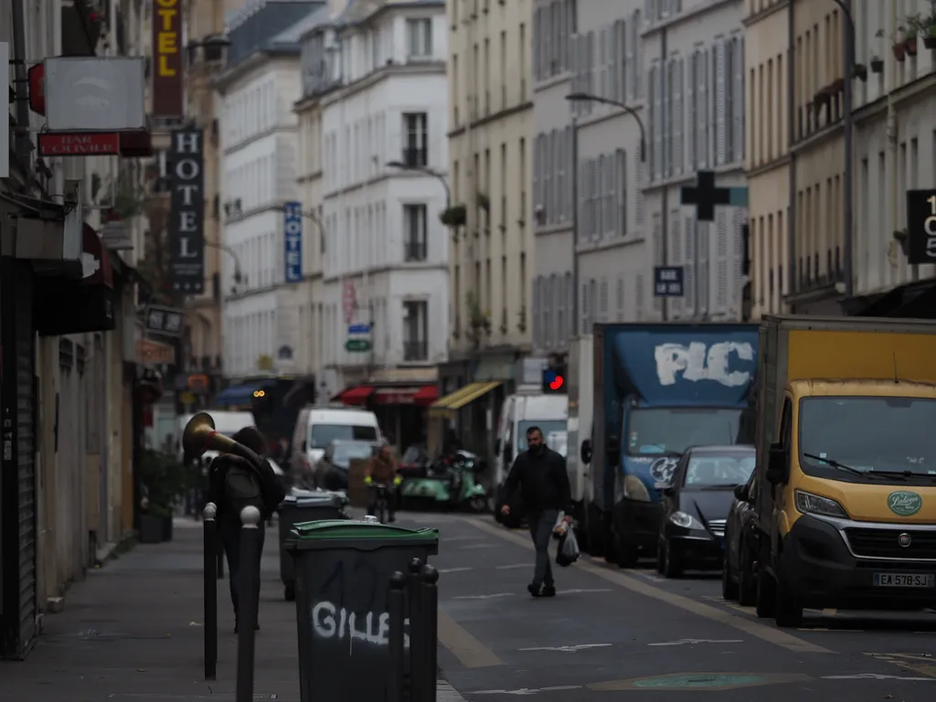 a person walking down a street with an instrument on their back