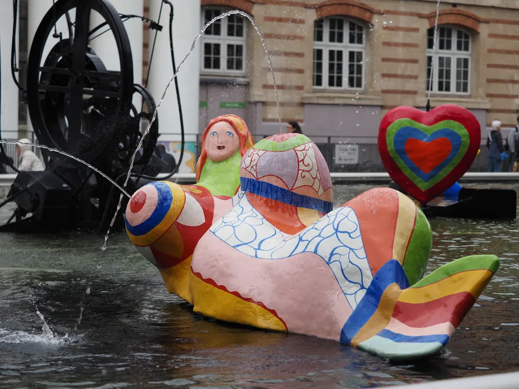 a large colourful mermaid firing water from her breasts