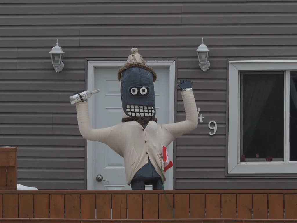 a wooden sculpture of Bender wearing a cardigan