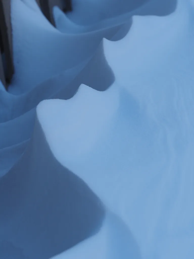 snow drifts along a fence