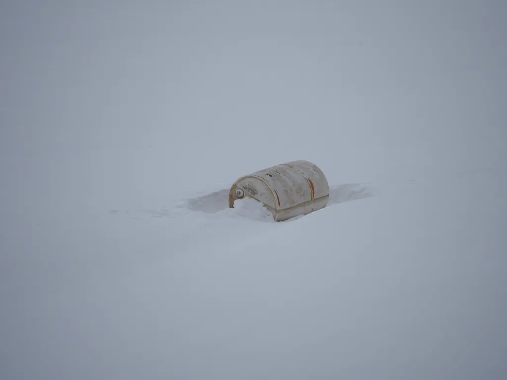 a large barrel lying in the snow