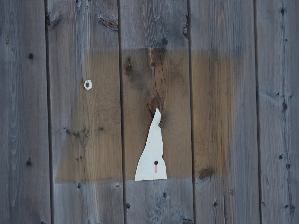 the outline of a now-removed sign on a fence