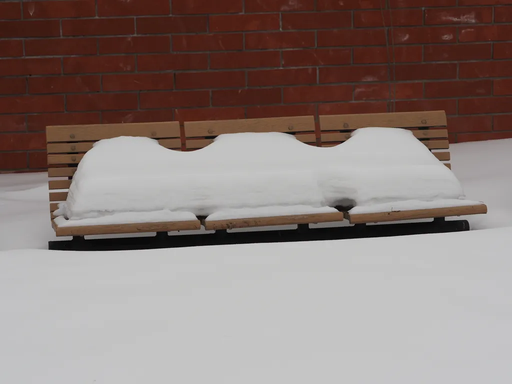 a park bench covered in snow