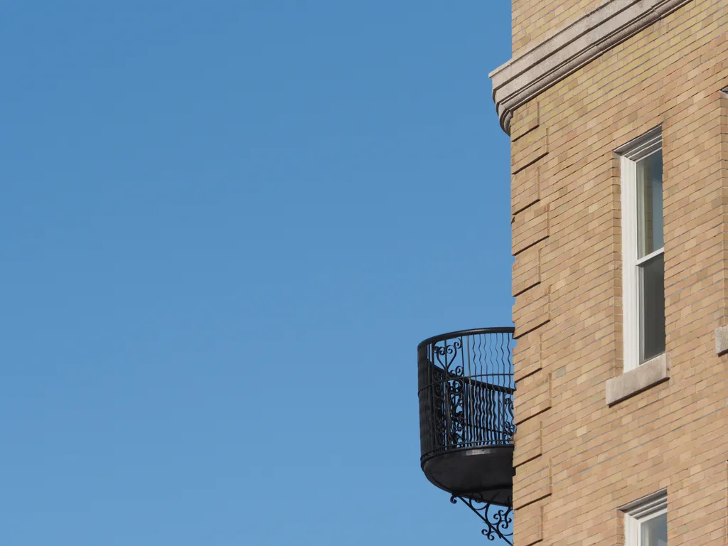 a brick building with a metal balcony