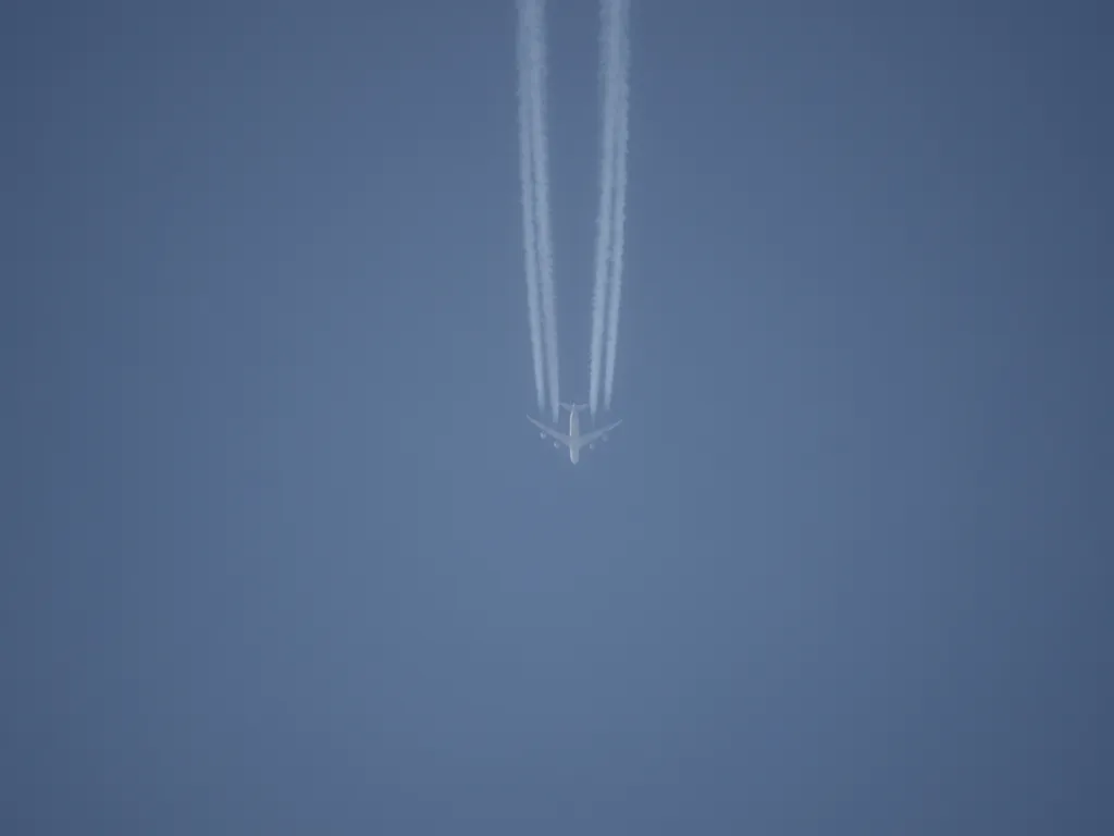 a plane flying in a blue sky