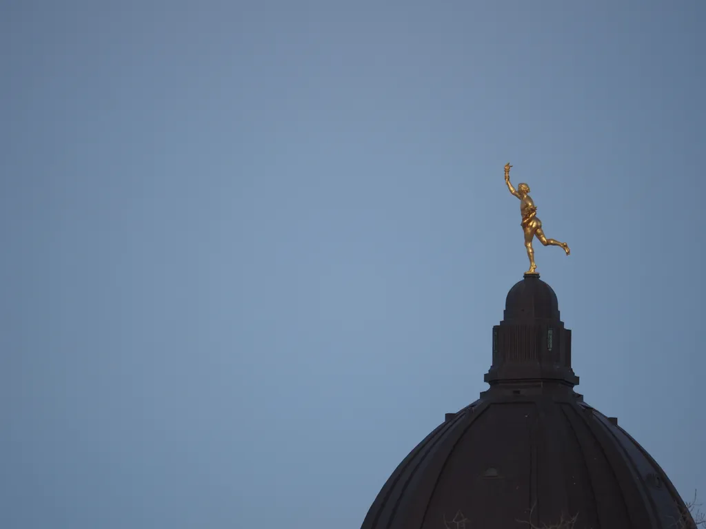 a golden statue on a domed building