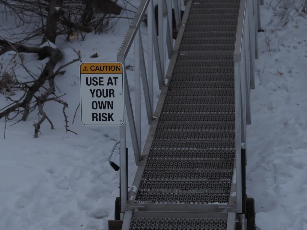 a sign by a ramp: caution: use at your own risk