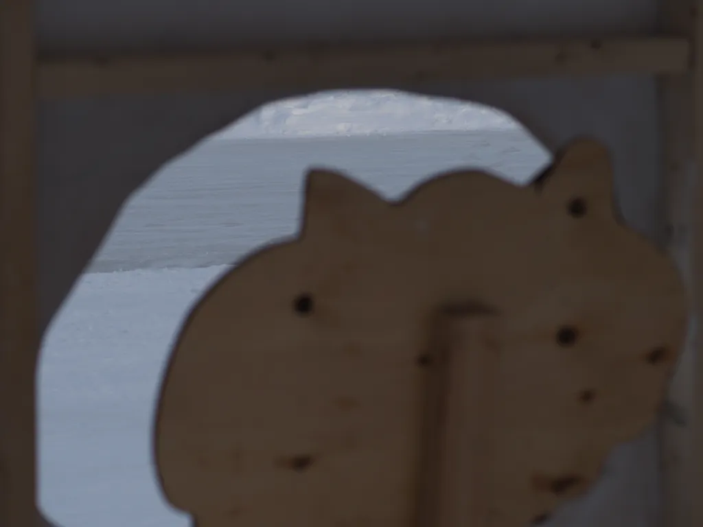 a warming hut built to resemble a child's depiction of a yeti in a cave as seen from behind