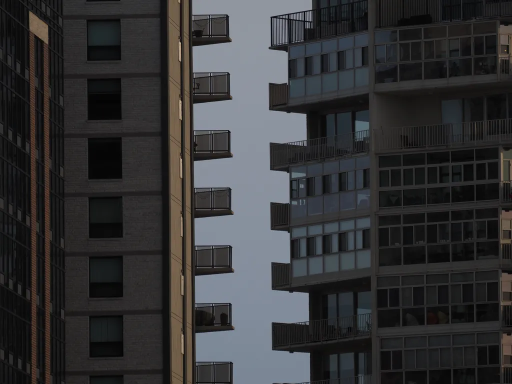 two tall apartment buildings with balconies beside each other