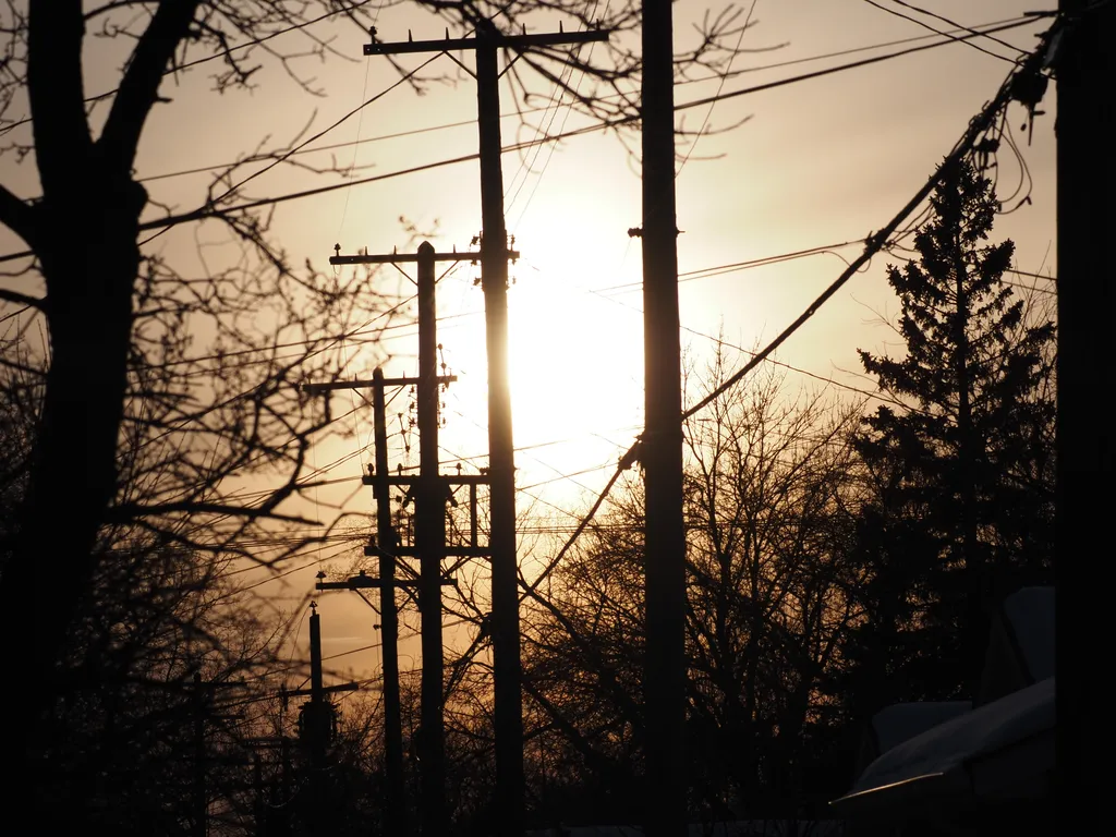 the sun setting behind utility poles