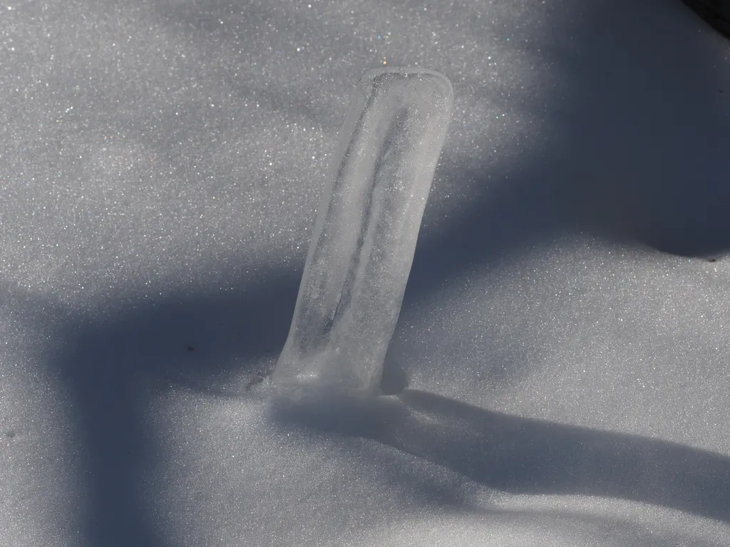 a chunk of ice sticking out of the snow