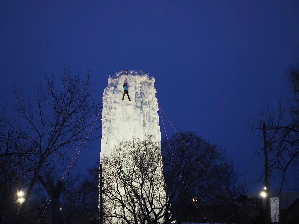 a person climing a tower made of ice at night