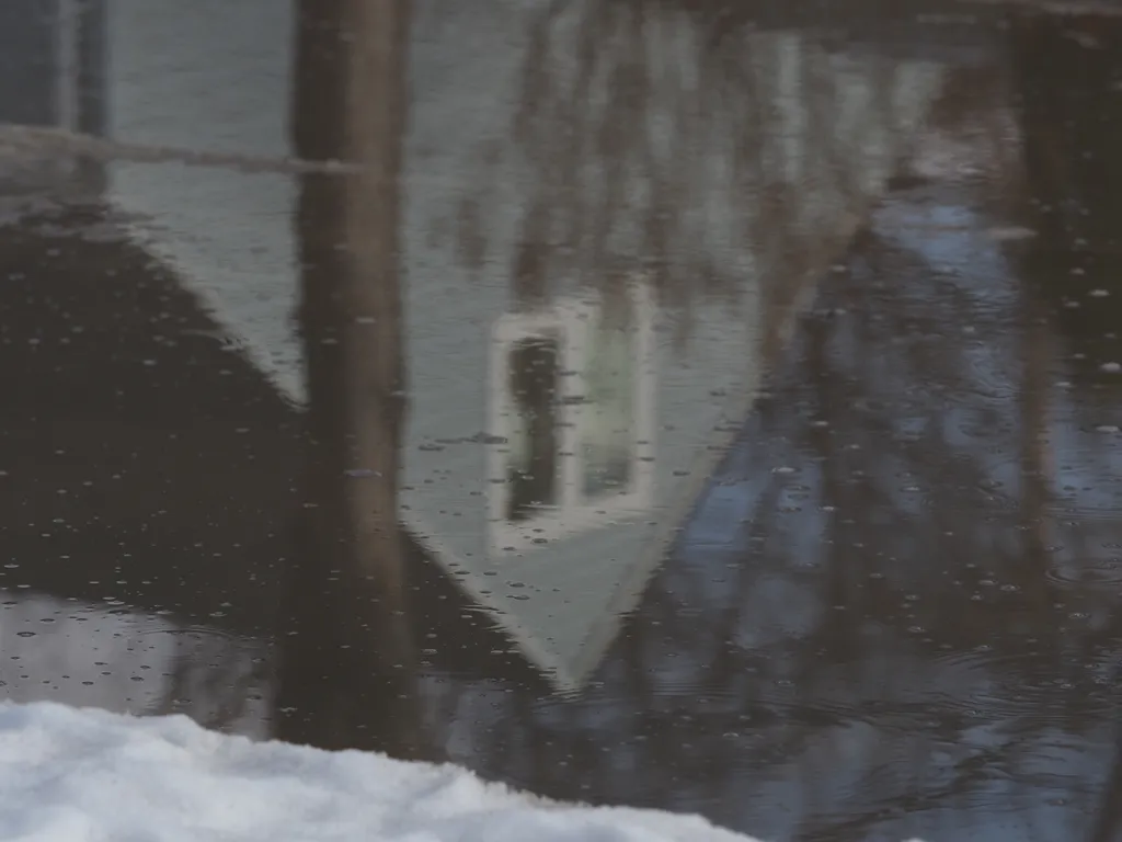 a house reflected in a large puddle