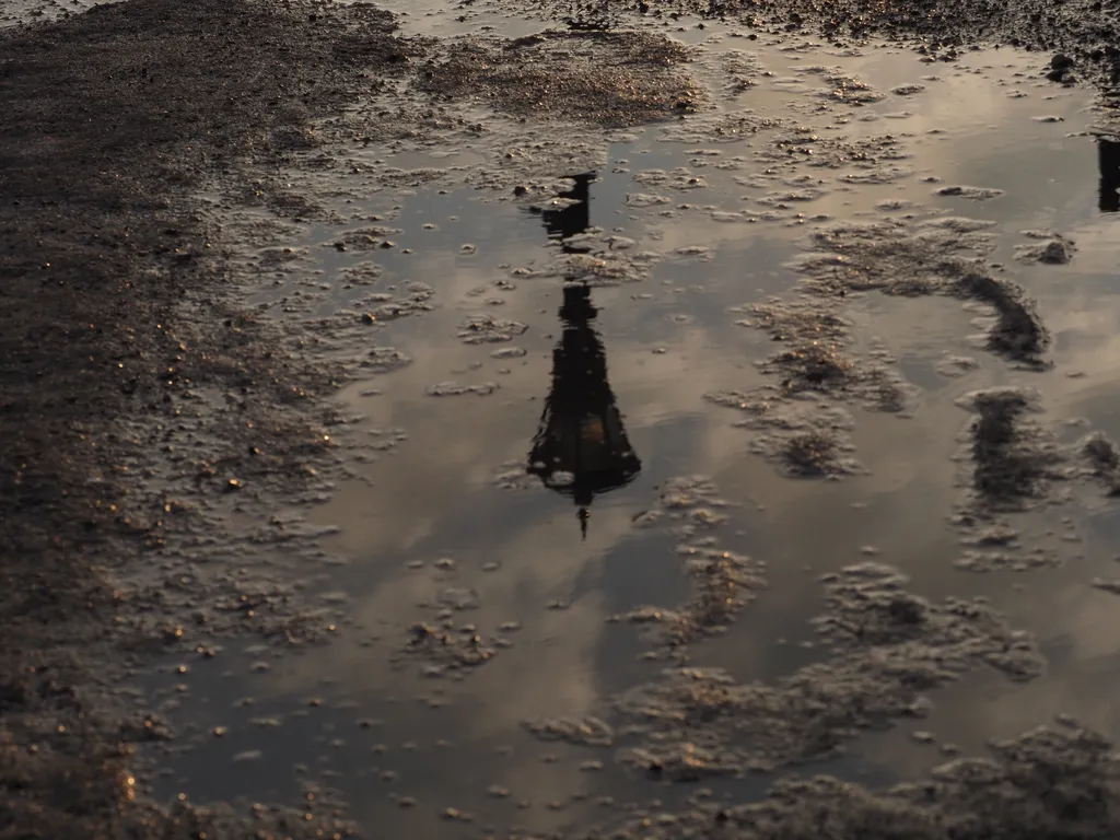 a streetlight reflected in a slushy puddle