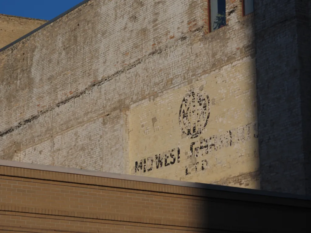 a faded sign on an old brick building