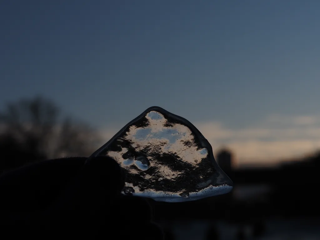 a clear piece of ice held up to the camera