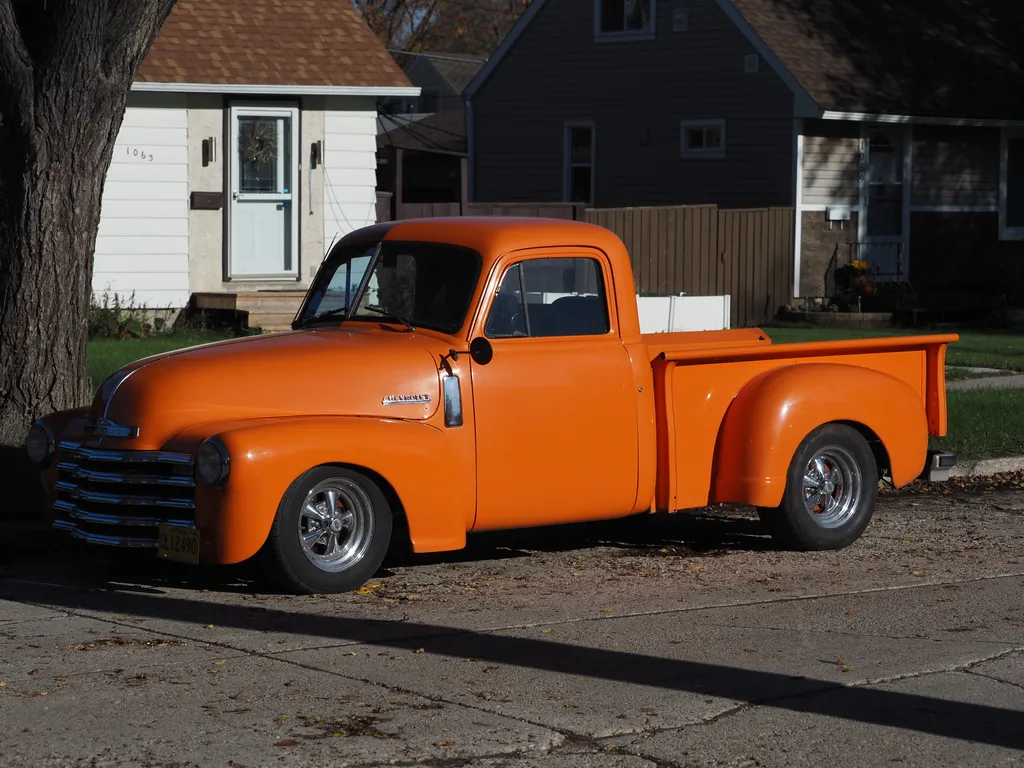an old pickup truck painted bright orange