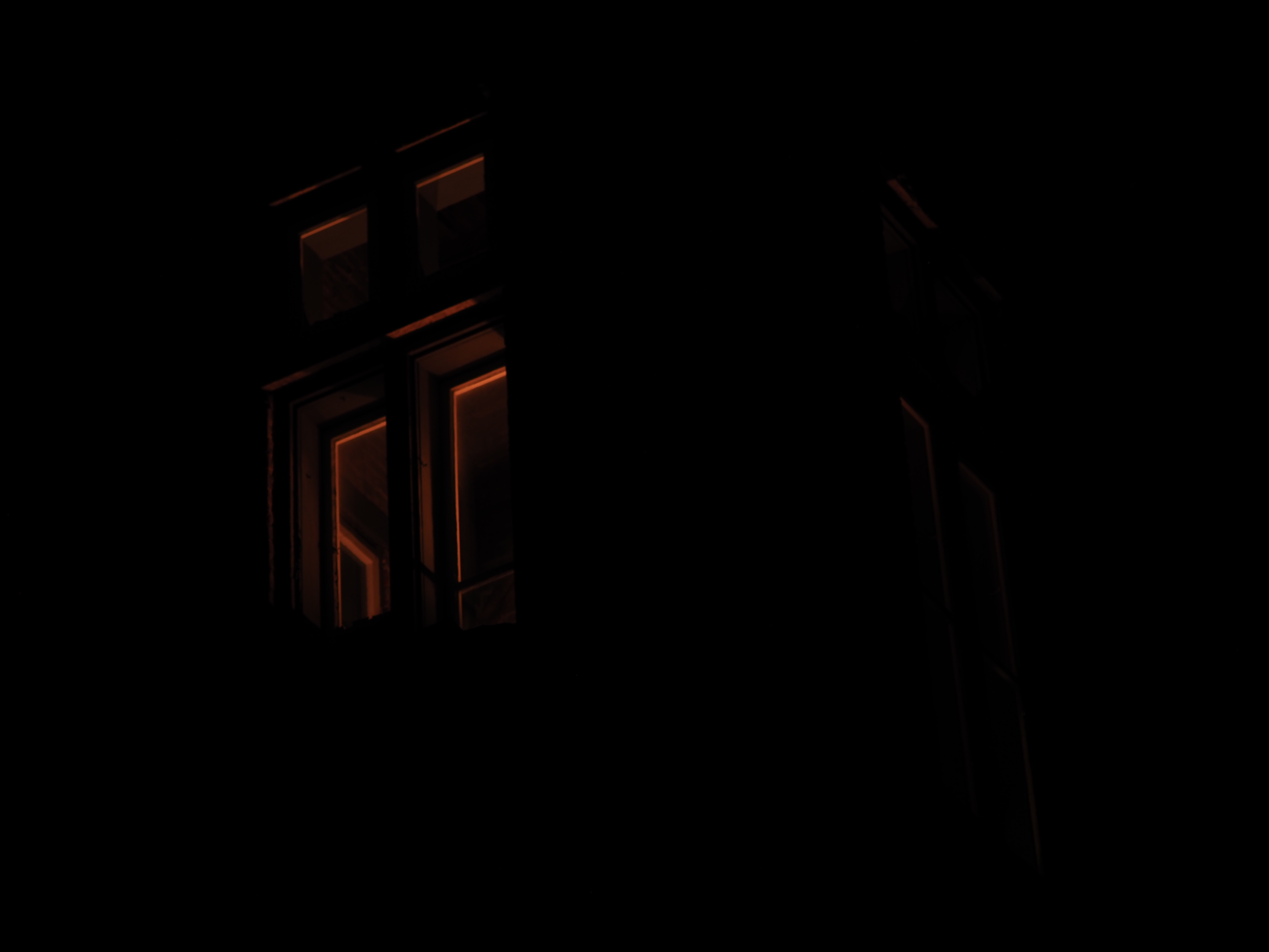 the tower of a former fire hall lit by red light at night