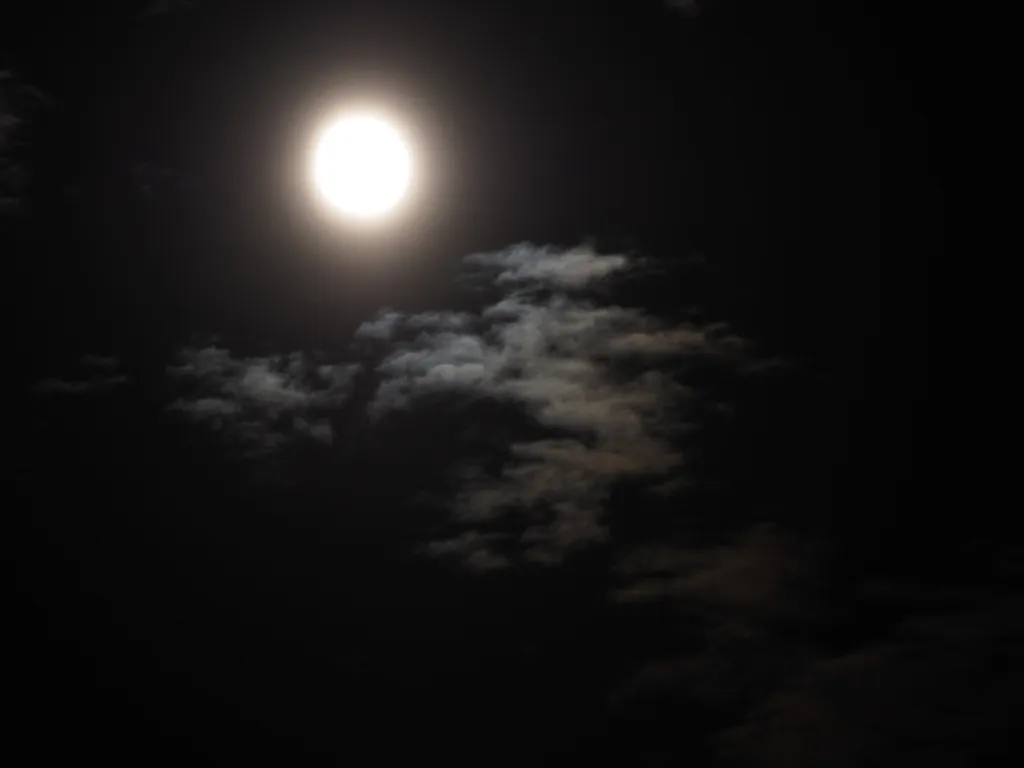 the moon behind clouds