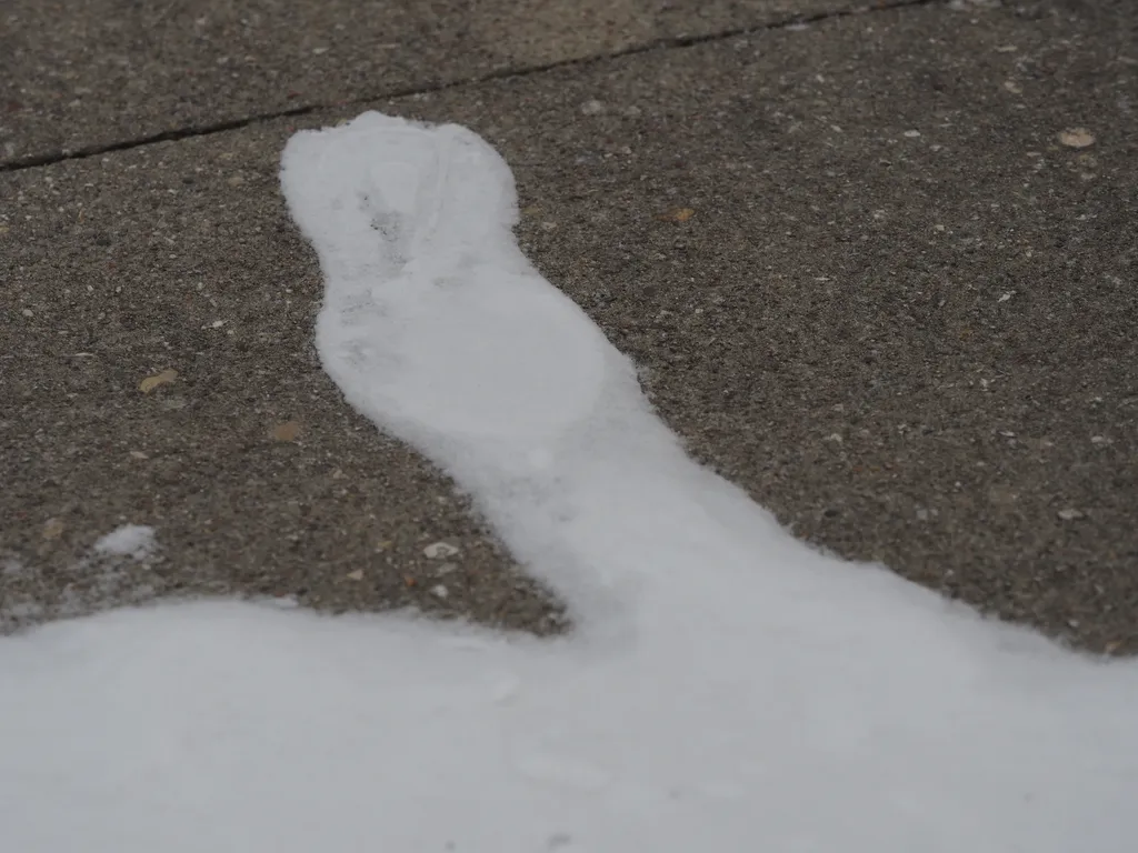 a snowy footprint on bare cement