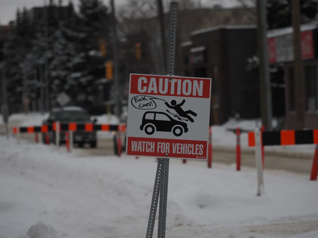 A sign with a car striking a pedestrian with the added text 